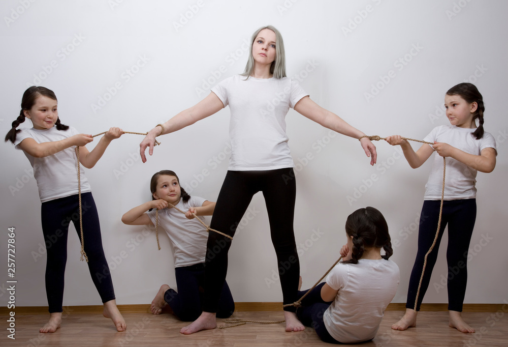Children pull mom in different directions. Mother of many children.  hyperactive children. Tired mom. tied with ropes. The relationship with the  mother is psychological immaturity. Family manipulations Stock Photo |  Adobe Stock