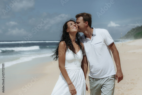 Happy couple walking at the beach, traveling at Bali.