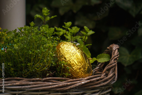 Golden chocolate easter egg in wooden basket