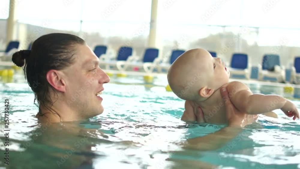 Father and his little son have fun in the pool. The child relaxed and lay back. Individual classes with kids in the pool Father and his little son have fun in the pool. The child relaxed and lay back. Individual classes with kids in the pool