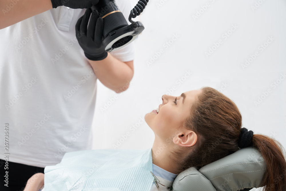 Man taking photo of teeth after whitening in dental office Man taking photo of teeth after whitening in dental office