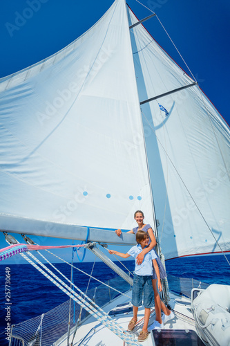 Boy with his sister on board of sailing yacht on summer cruise.