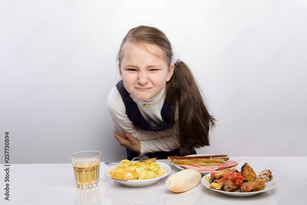 Girl sits at the table and going to drink tablets. Headache. hangover, bad state of health, insomnia. holding hands behind his head Girl sits at the table and going to drink tablets. Headache. hangover, bad state of health, insomnia. holding hands behind his head