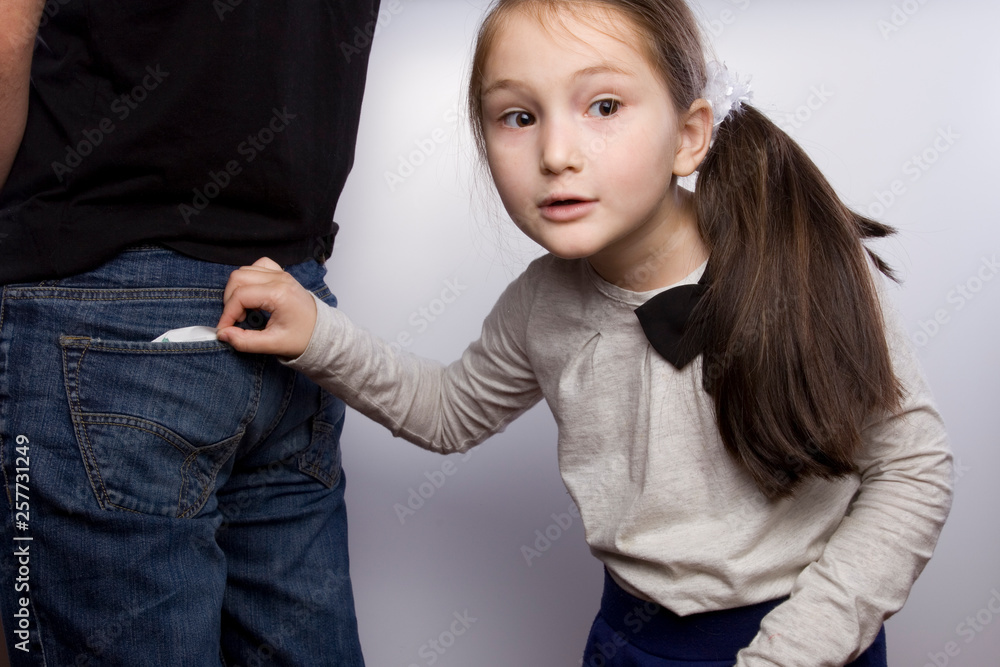 the girl pulls out of daddy's purse. child theft. stealing from parents
