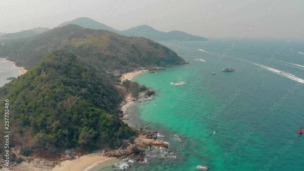 green hilly island surrounded by boundless azure ocean with motorboats on sunny tropical day aerial view green hilly island surrounded by boundless azure ocean with motorboats on sunny tropical day aerial view