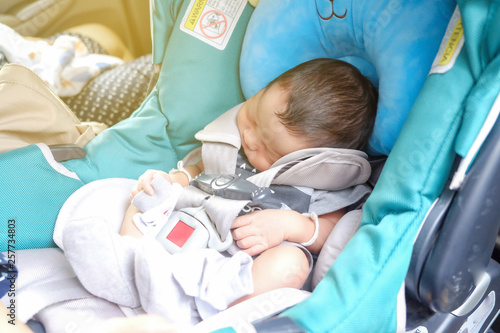 Mom with infant child boy inside savfty car seat