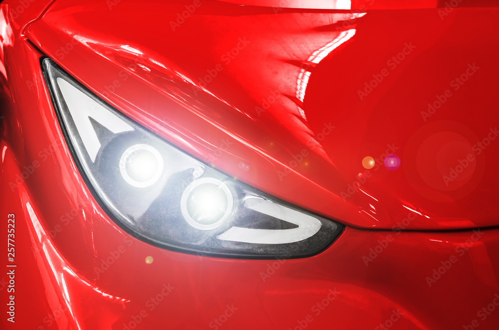 Headlight of a red sports car.
