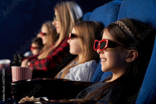 People, kids watchng movie in 3d glasses in cinema. © serhiibobyk