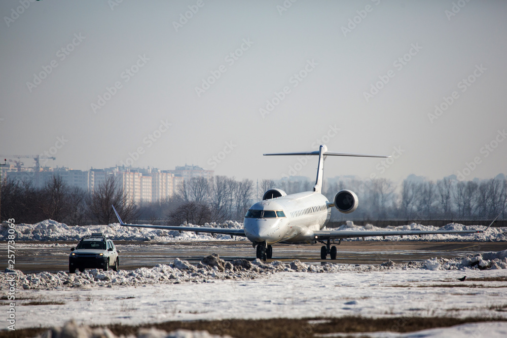 Passenger plane at airport in winter afternoon. plane on airport platform in winter. Airplane on summer strip in winter Passenger plane at airport in winter afternoon. plane on airport platform in winter. Airplane on summer strip in winter