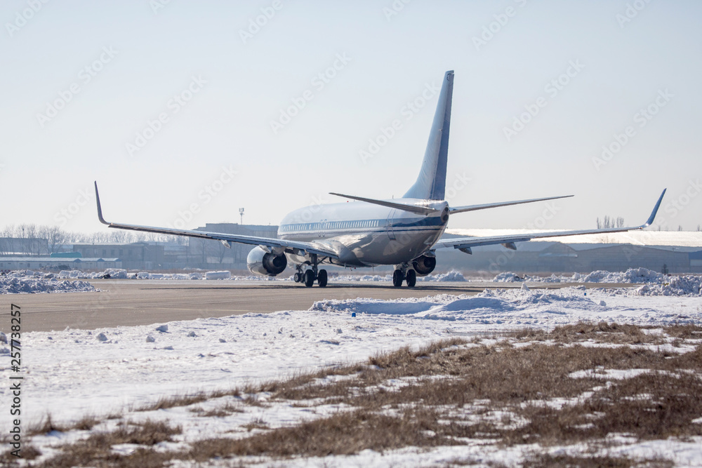 Passenger plane at airport in winter afternoon. plane on airport platform in winter. Airplane on summer strip in winter Passenger plane at airport in winter afternoon. plane on airport platform in winter. Airplane on summer strip in winter