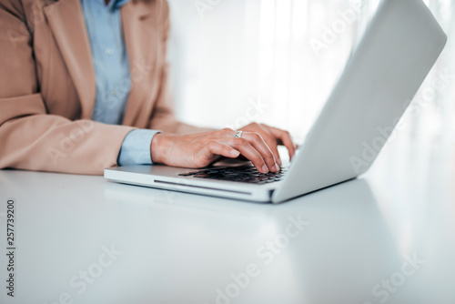 Business concept. Close-up image of woman in formal wear typing on laptop.