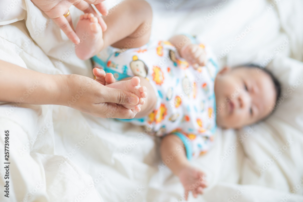 Mother making infant baby boy foot massage Mother making infant baby boy foot massage