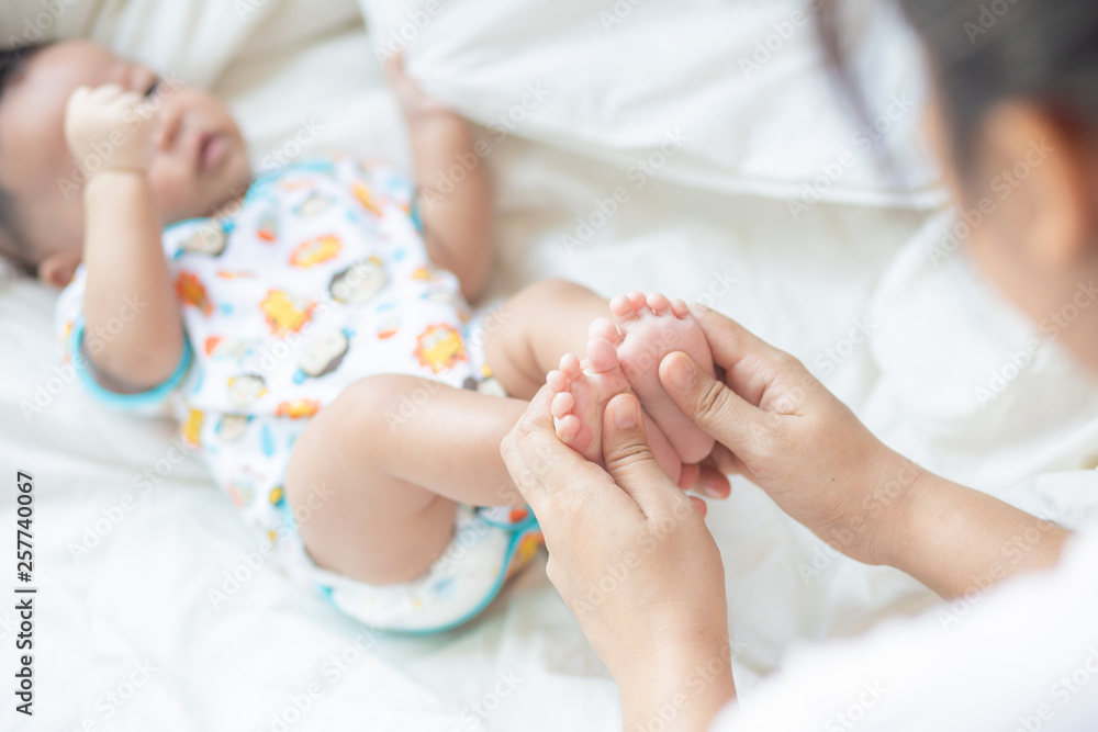 Mother making infant baby boy foot massage Mother making infant baby boy foot massage