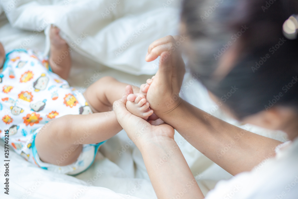 Mother making infant baby boy foot massage Mother making infant baby boy foot massage