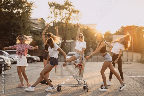 Young women with a supermarket cart have fun