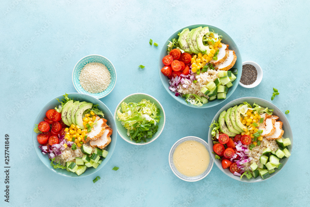 Lunch bowls with grilled cgicken meat, rice and fresh salad of avocado, cucumbers, corn, tomato and onion Lunch bowls with grilled cgicken meat, rice and fresh salad of avocado, cucumbers, corn, tomato and onion