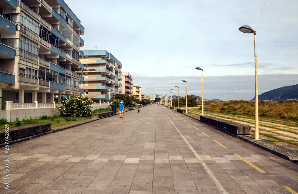 Castro Urdiales, Spain-Septemeber 2019. People and tourist walking in the promenade with big building in one side. Castro Urdiales, Spain-Septemeber 2019. People and tourist walking in the promenade with big building in one side.