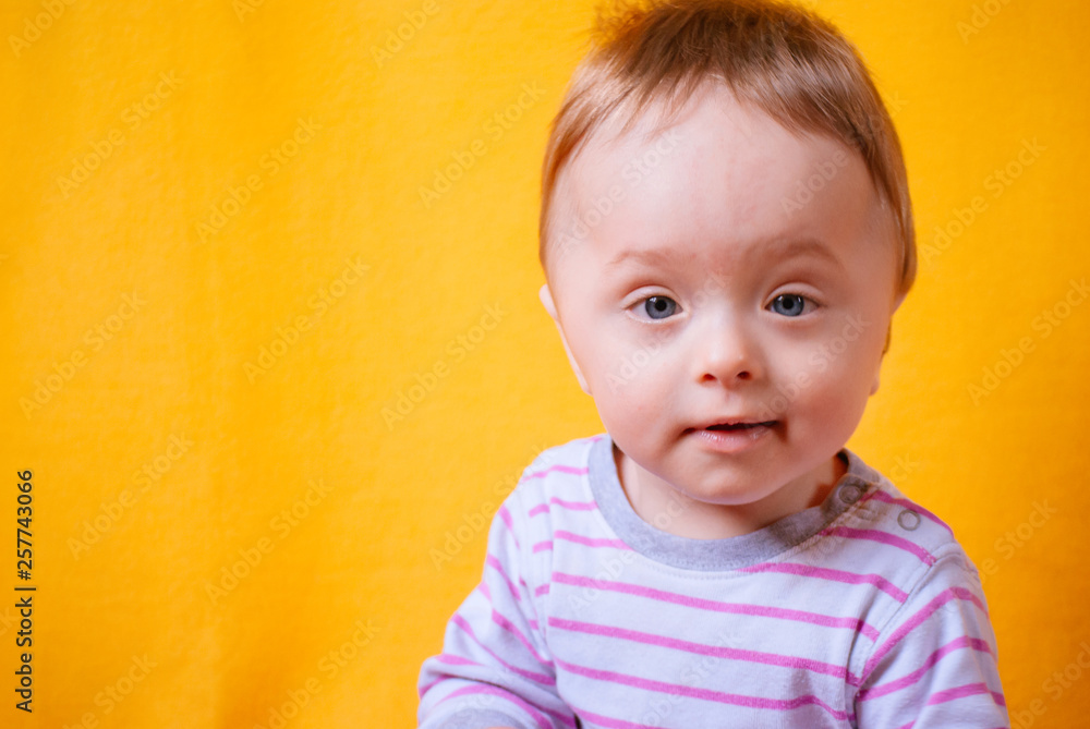 Portrait of a staring baby boy under one year (8 months) old, on a solid yellow background Portrait of a staring baby boy under one year (8 months) old, on a solid yellow background