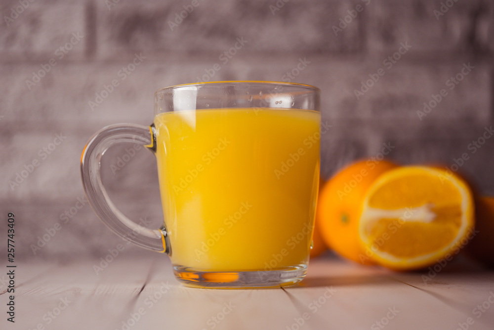 Glass of freshly squeezed orange juice standing on light background with a fresh oranges. Healthy lifestyle concept Glass of freshly squeezed orange juice standing on light background with a fresh oranges. Healthy lifestyle concept