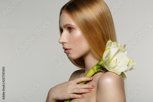 Side view portrait of young blonde female model with perfect skin