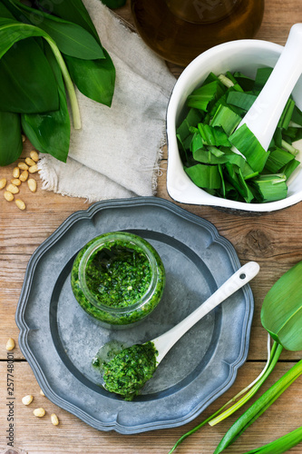 Ramson pesto and ingredients for cooking it on a wooden table. Rustic style. photo