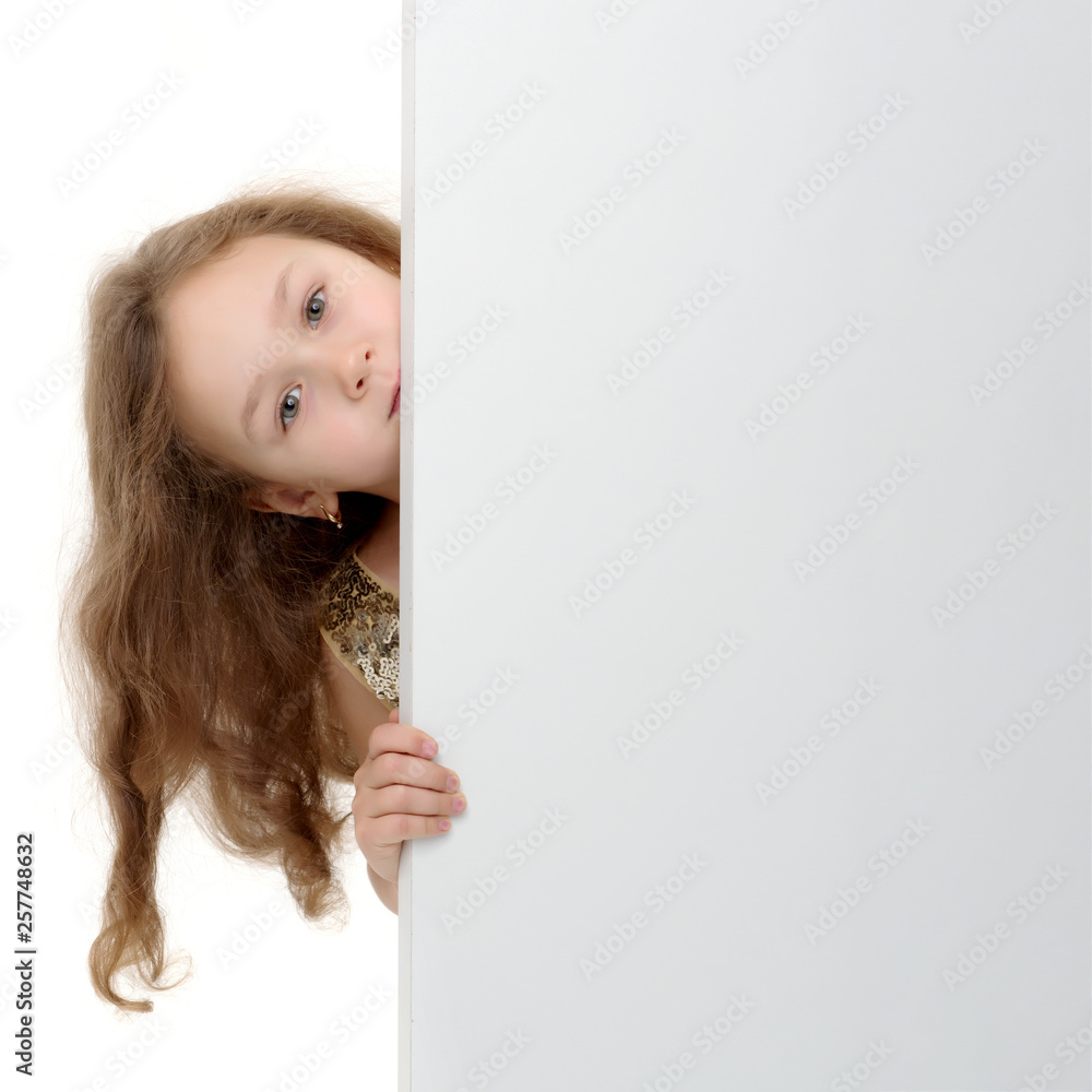 A little girl is looking from behind an empty banner. A little girl is looking from behind an empty banner.