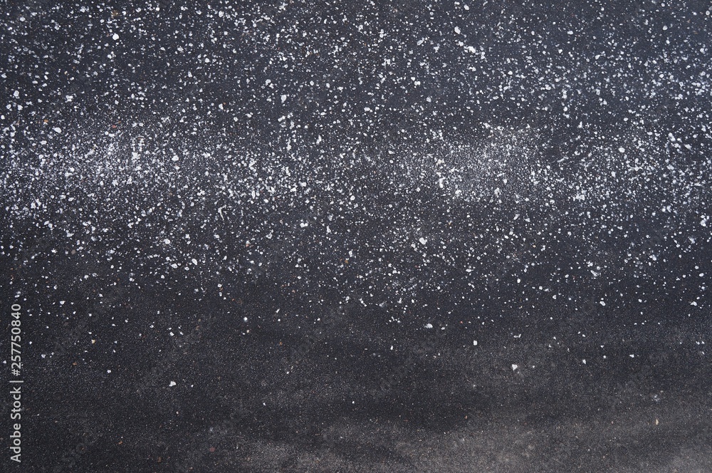 Obraz premium texture of white crystals on a black background, scattered evenly on one side