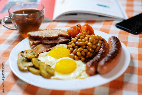 Traditional English or Irish breakfast: sausages, bacon, egg, mushrooms, tomatoes and toasts. Nutritious morning meal. horizontal