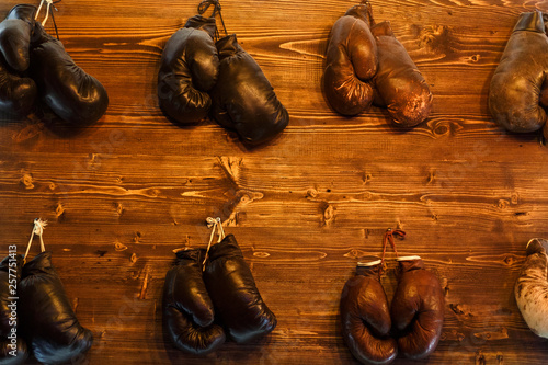 Photo of several boxing gloves hanging on wall
