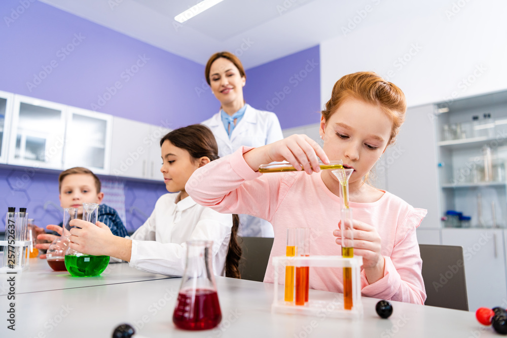 Pupils with flasks doing chemical experiment during chemistry lesson Pupils with flasks doing chemical experiment during chemistry lesson