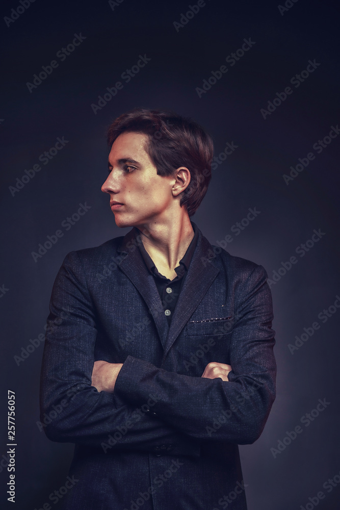 Portrait of an expressive, stylish, young man in a strict suit in orange tones with a smoky background Portrait of an expressive, stylish, young man in a strict suit in orange tones with a smoky background