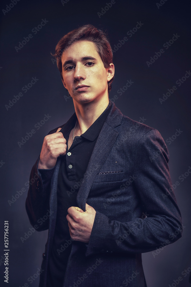 Portrait of an expressive, stylish, young man in a strict suit in orange tones with a smoky background Portrait of an expressive, stylish, young man in a strict suit in orange tones with a smoky background