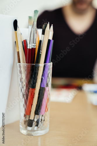 glass with pens and pencils on the table in the classroom for learning to draw.