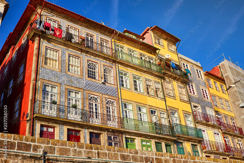 Colorful houses of Porto Ribeira, traditional facades, old multi-colored buildings with red roof tiles on the embankment in the city , Portugal