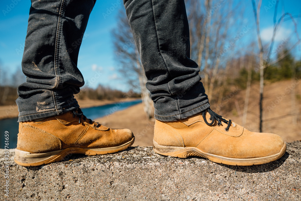 Yellow boots with thick soles for hard work and walking, man in shoes outdoors Yellow boots with thick soles for hard work and walking, man in shoes outdoors