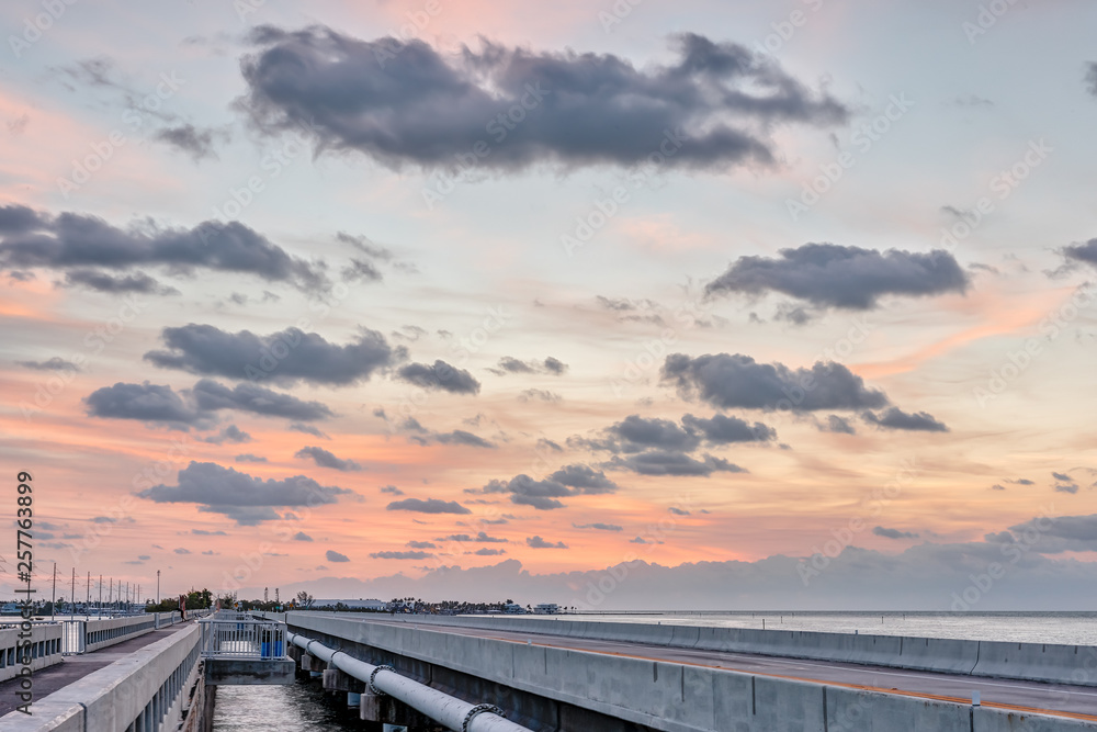 Sunrise in Islamorada, Florida Keys with orange pastel blue hdr sky and overseas highway road in village of islands by gulf of Mexico horizon