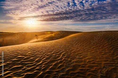 Beautiful sunset in sand dunes over desert