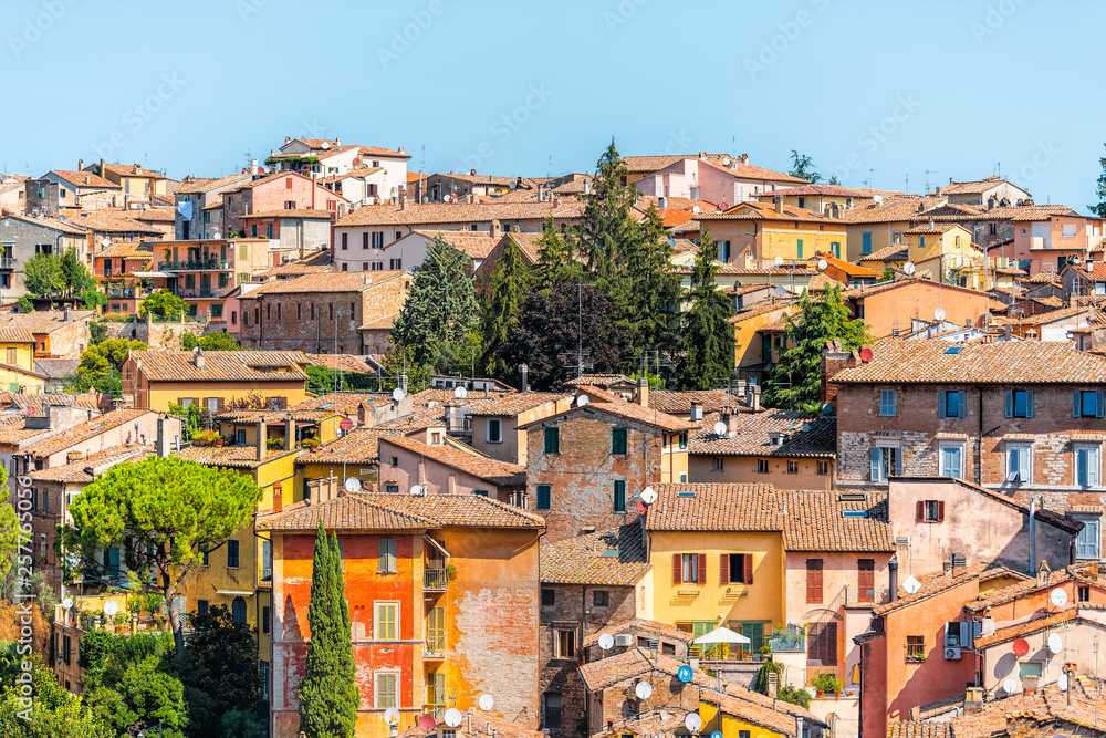 Perugia, Italy Umbria cityscape with historic old medieval Etruscan buildings and rooftops of town village yellow orange colors in summer satellite dishes