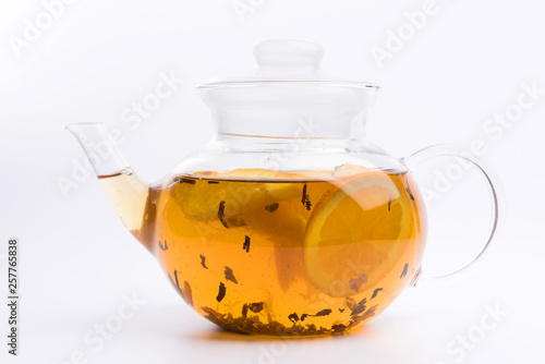 Glass teapot with green tea isolated on white background