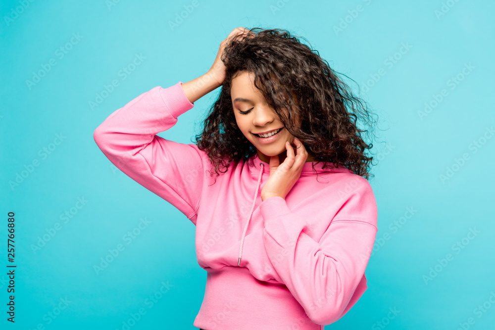 smiling african american young woman touching face isolated on blue smiling african american young woman touching face isolated on blue