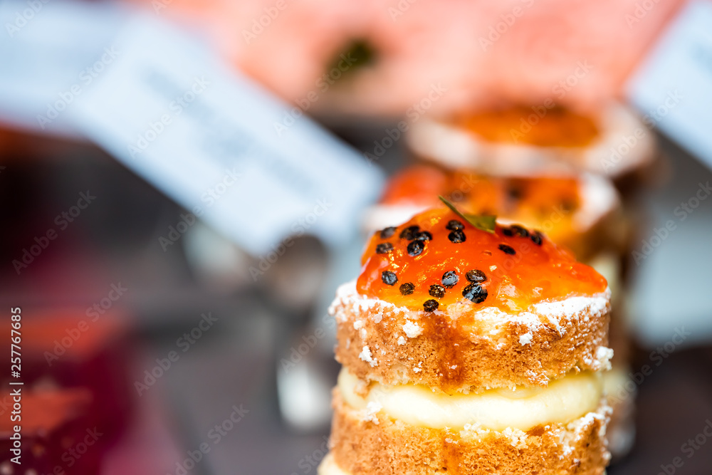 Φωτογραφία Small orange layered cake slice dessert on tray display in street food market or
