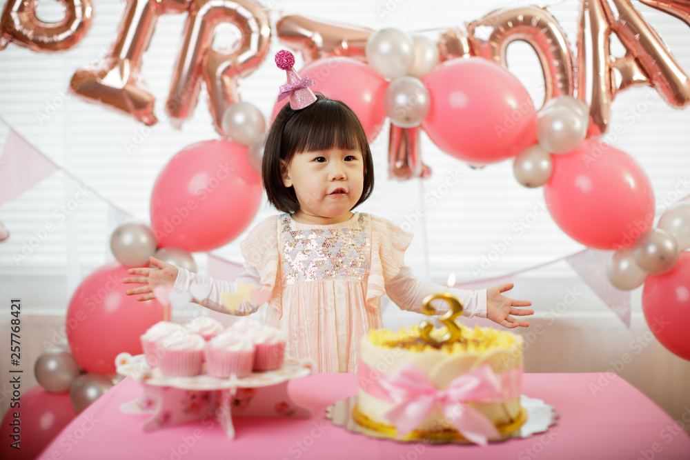 Fototapeta premium toddler girl celebrating her third birthday at home