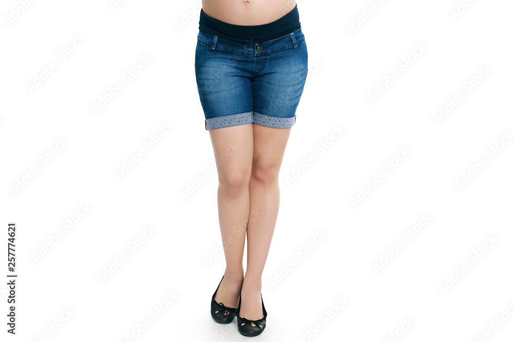 Pregnant woman in blue jeans shorts isolated white background Pregnant woman in blue jeans shorts isolated white background