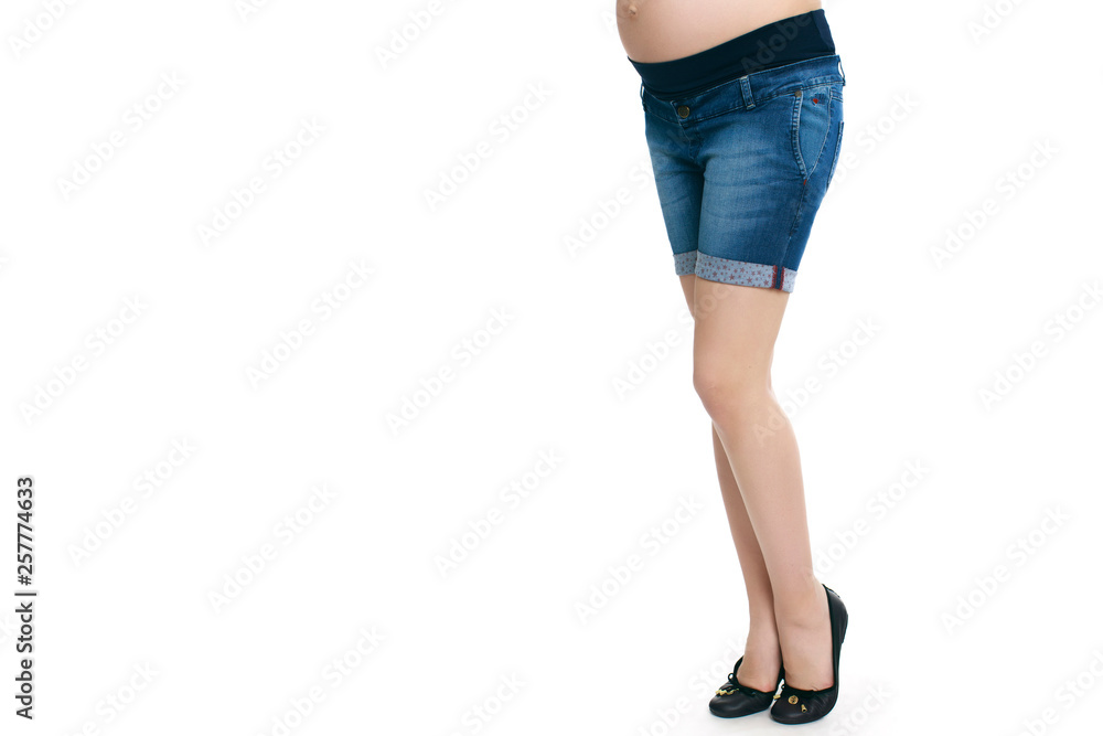 Pregnant woman in blue jeans shorts isolated white background Pregnant woman in blue jeans shorts isolated white background