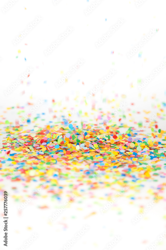 Colored confetti flying on white background