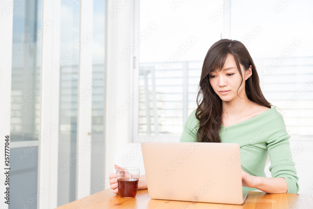 部屋でラップトップコンピューターを見る女性 部屋でラップトップコンピューターを見る女性