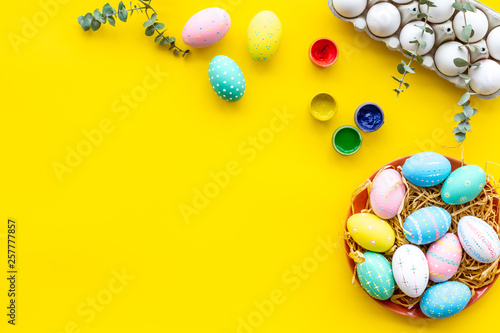 eggs with colorful paint for easter tradition on yellow background top view mockup