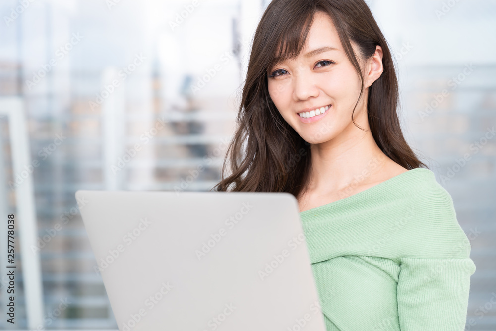 部屋でラップトップコンピューターを見る女性 部屋でラップトップコンピューターを見る女性