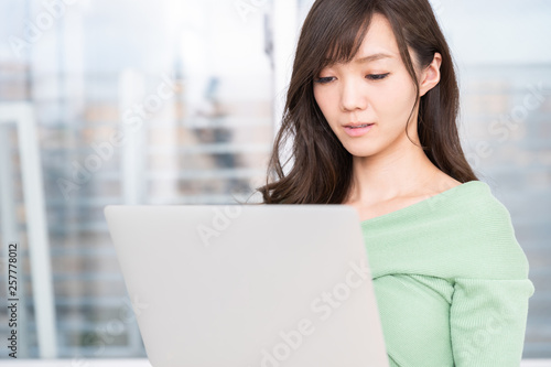 部屋でラップトップコンピューターを見る女性