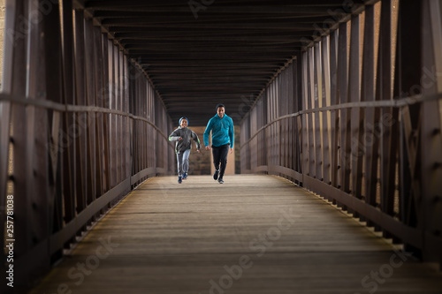 Two Hispanic Brothers Run A Race Down Bridge © cmlndm